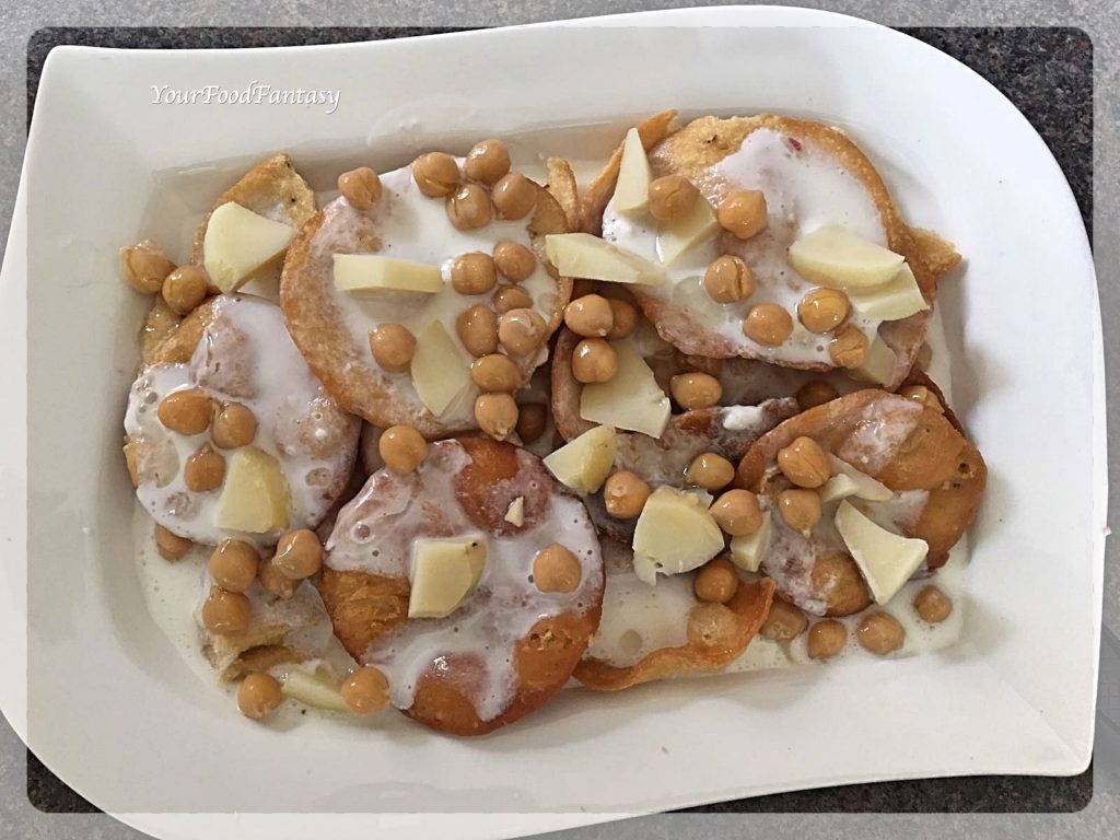 Layering papdi, yogurt, potato, chickpeas for papdi chaat